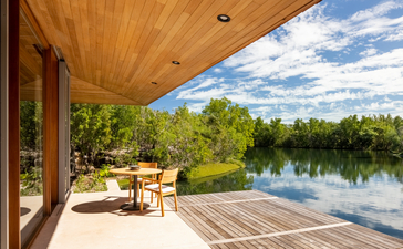 Pond pavilion with wooden ceiling and open terrace overlooking calm water at Amanyara, Turks and Caicos.