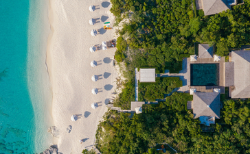 安缦涯澜度假村四卧室海滩别墅的空中俯瞰图，展示白沙滩和绿松石色海水。
