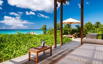 Four-bedroom beachfront villa sala at Amanyara with wooden deck overlooking turquoise Caribbean waters.