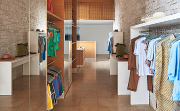 アマンゾイのビーチクラブで、タオルやスイムウェアが整理されたオープンエアの更衣室。