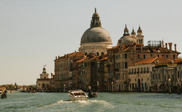 Aman Venice exterior overlooking the Grand Canal with basilica dome and historic Venetian architecture.