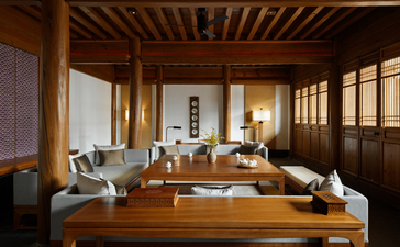 Amandayan villa living area with wooden furnishings, shoji screens, and natural light from floor-to-ceiling windows.