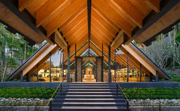 Boutique Aman Essentials nel resort Amanpuri in Tailandia, con architettura in legno e pietra al tramonto.