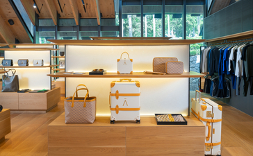 Aman Essentials Boutique at Amanpuri resort, displaying clothing and wellness products on wooden shelving and display surfaces.
