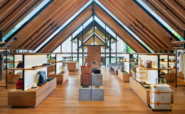 Aman Essentials Boutique at Amanpuri resort in Thailand, with wooden display cases and cream-coloured furnishings beneath a pitched timber ceiling.