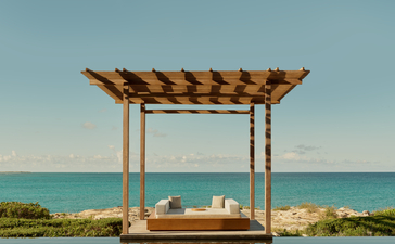 Pergola en bois surplombant une piscine infinie face à la mer turquoise à Amanyara.