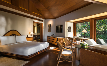 Principal bedroom at Amanpulo resort with wooden ceiling, natural light and mid-century furnishings.
