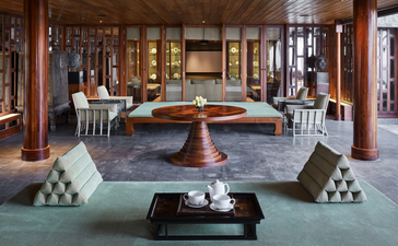 Eight-bedroom ocean villa lounge at Amanpuri, with teak furnishings and ocean views through open doors.