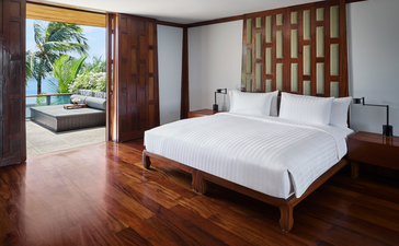 Spacious lounge in a seven-bedroom garden villa at Amanpuri, featuring wooden flooring, contemporary furnishings, and garden views through expansive windows.