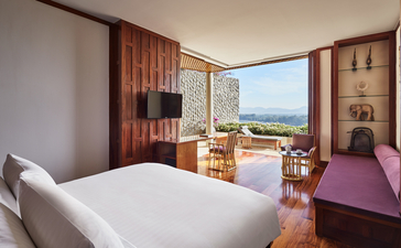 アマンプリのリゾートにある7室ベッドルームの寝室。木製の壁面と海の眺めを備えた明るい空間。