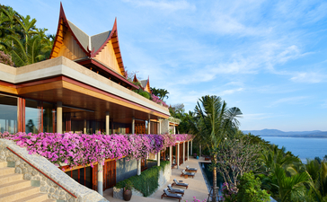 アマンプリのテラスから海を眺める、七寝室ヴィラ。ピンクの花が咲く庭園とタイ建築が特徴。