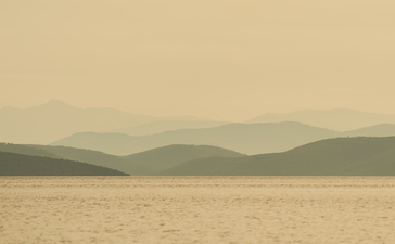 Calm waters and distant mountains at Amanruya's beach club.