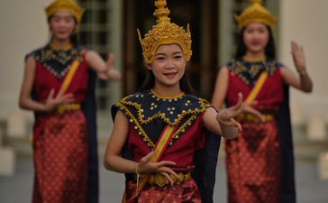Lao dancers in traditional crimson silk costumes performing at Amantaka's poolside dinner celebration.