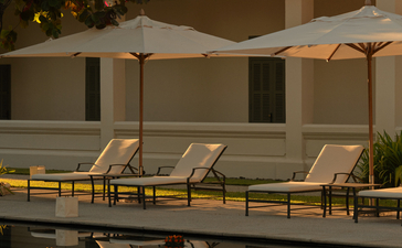 Candlelit floats during Loy Krathong ceremony at Amantaka's pool terrace at dusk.