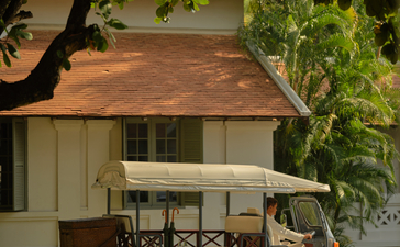 Tuk-tuk parked beneath trees at Amantaka, Laos resort.