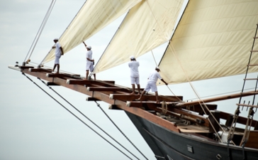 Crew members on the bow of a traditional wooden sailing vessel at Amandira, Indonesia.