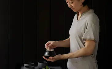 Spa therapist preparing traditional wellness treatment at Aman Kyoto resort, Kyoto, Japan.