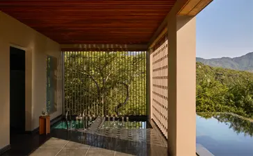 Forest wellness pool villa terrace overlooking water and mountains at Amanoi, Vietnam.