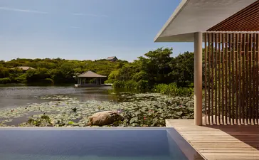 Amanoi wellness pool villa terrace overlooking a serene lake and verdant landscape in Vietnam.