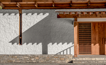 Amankora Paro Lodge arrival courtyard with modernist architecture and traditional wooden detailing.