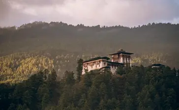 Amankora lodge nestled amongst forested hills in Bumthang Valley, Bhutan.