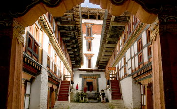 Gilded interior courtyard of Jakar Dzong at Amankora, with ornate wooden galleries and traditional Bhutanese architectural details.