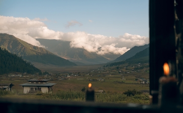 Snow-capped mountains rise beyond the Gangtey valley at Amankora, seen from a window at dusk.