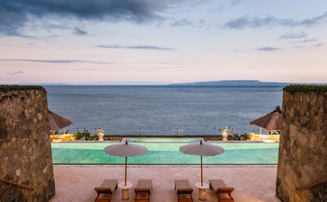 Amankila resort's main pool overlooking the sea at sunset, Bali.