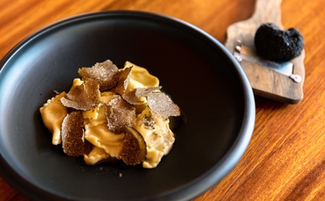 アマンプリのイタリアンレストラン、アルヴァで提供されるパスタ料理。黒いプレートに盛られた黄金色のリボン状パスタ。