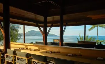 Nama Omakase counter at Amanpuri with wooden bar seating overlooking coastal views.