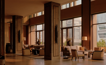 曼谷奈乐安缦酒店宽敞的大堂，深色木质框架和柔和灯光营造温暖氛围。