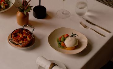 Dining table setting at Aman Nai Lert Bangkok with plated dishes and table appointments.