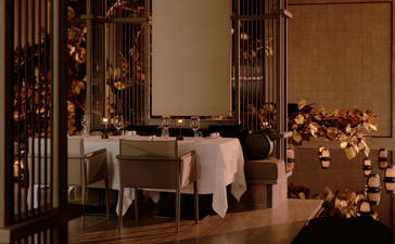 Intimate dining room at Aman Nai Lert Bangkok with warm lighting and festive decorations.