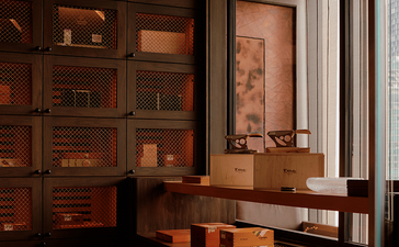 Cigar bar at Aman Nai Lert Bangkok with wooden cabinetry and display cases.