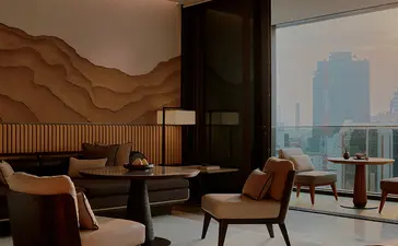 曼谷奈乐安缦酒店房间，配有木质特色墙面、现代家具和曼谷城市景观窗景。