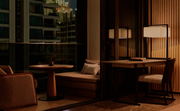 غرفة فندق بأمان ناي ليرت بانكوك مع مقاعد جلوس وإضاءة دافئة في المساء.