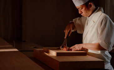 Artisan craftsperson at work in a wooden boat at Aman Nai Lert Bangkok.