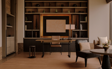 Study in an Aman Suite at Aman Nai Lert Bangkok, featuring built-in shelving, a desk, and a mid-century style chair.