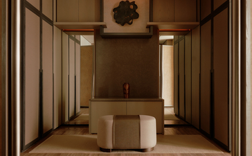 アマン ナイラート バンコクのプレミア コーナー スイートの寝室、ベージュ色の壁と木製パネルで設計された空間。