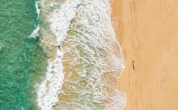 Plage de sable fin avec vagues turquoise à Amanera, resort en République dominicaine.