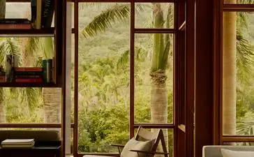 Biblioteca del resort Amanera con ventanales que enmarcan la vegetación tropical dominicana.
