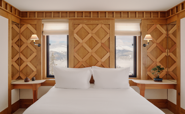 Chambre Nord bedroom at Aman Le Mélézin with twin beds, geometric wood panelling and Alpine views.