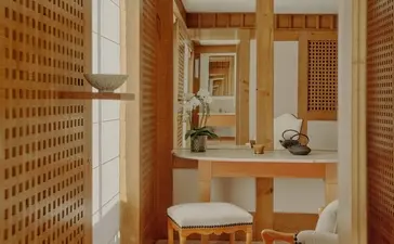 Bathroom at Aman Le Mélézin with wooden vanity, mirror and woven wall panelling.