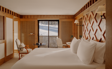 Chambre avec lits jumeaux aux murs en bois clair, Aman Le Mélézin.