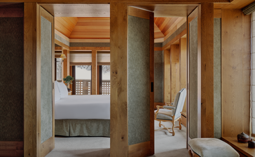 Aman Le Mélézin suite bathroom with wooden cabinetry and stone finishes.