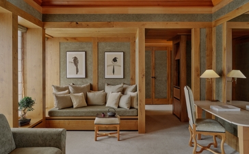 Accommodation suite at Aman Le Mélézin with seating area, framed artwork and wooden architectural details.