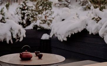 Warm bath overlooking snowy Alps at Aman Le Mélézin, French ski resort.