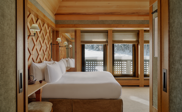 Principal bedroom suite with wooden furnishings and traditional lattice screens at Aman Le Mélézin, France.