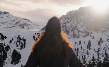 Person snowshoeing in snowy mountains at Aman Le Mélézin, France.