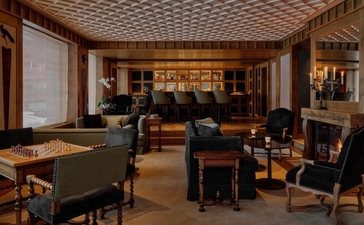 Aman Le Mélézin's salon with billiard tables, seating areas and warm wood finishes.